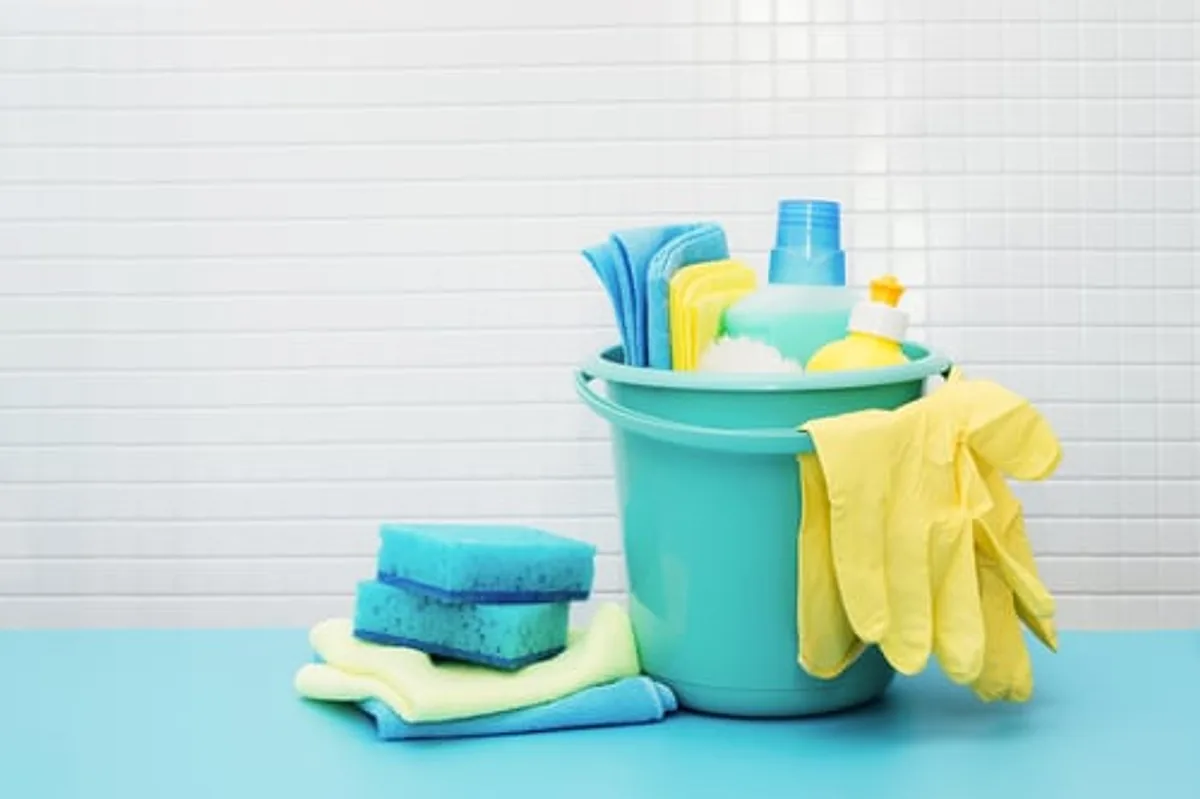 Cleaning bucket with folded cloths and sponges prepared for a recurring cleaning visit